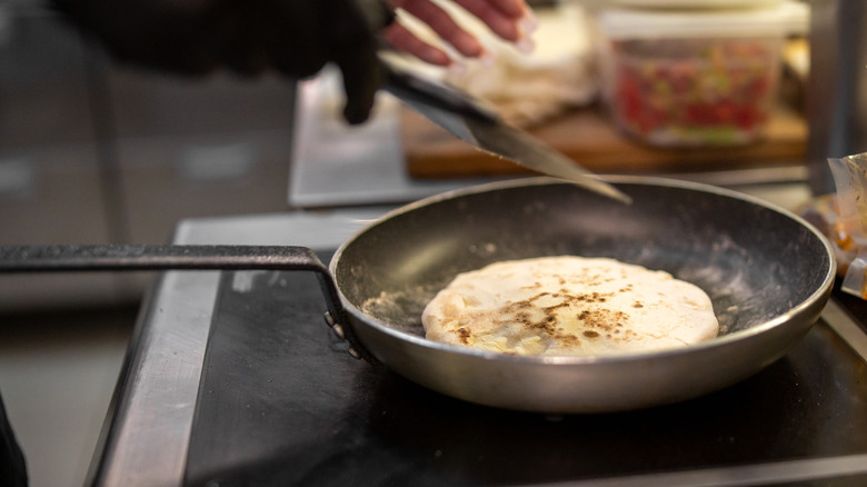 Small quesadilla cooking in a frying pan