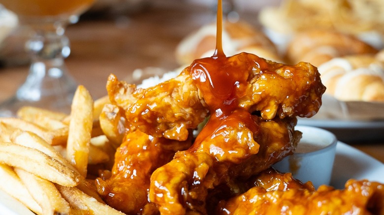 Cheddar's Scratch Kitchen chicken tender platter with sauce being drizzled over top