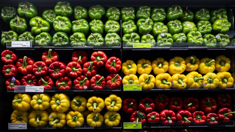 Display of green, red, and yellow bell peppers
