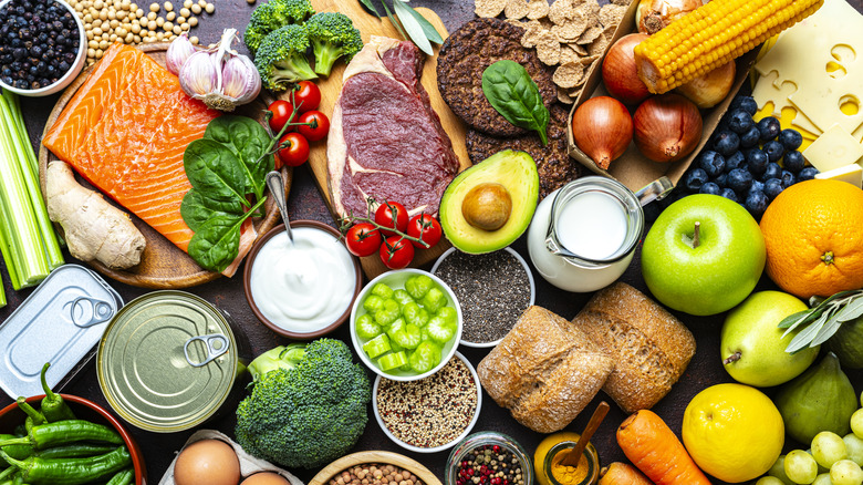 Assortment of produce, meats, fish, and other food ingredients spread across a table