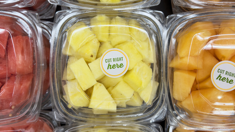 Precut watermelon, pineapple, and cantaloupe chunks in plastic containers