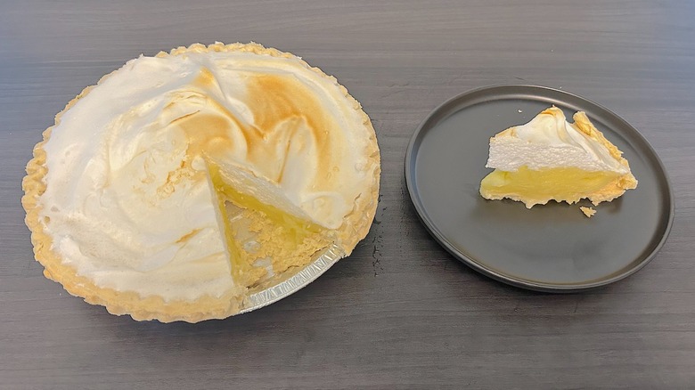 Hy-Vee lemon meringue pie with slice missing and slice on a black plate