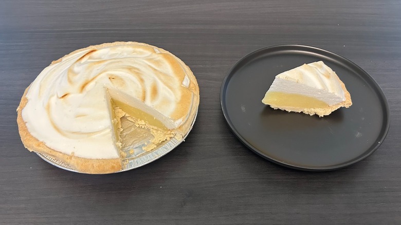 Schnuck's lemon meringue pie with a slice missing and the slice on a black plate