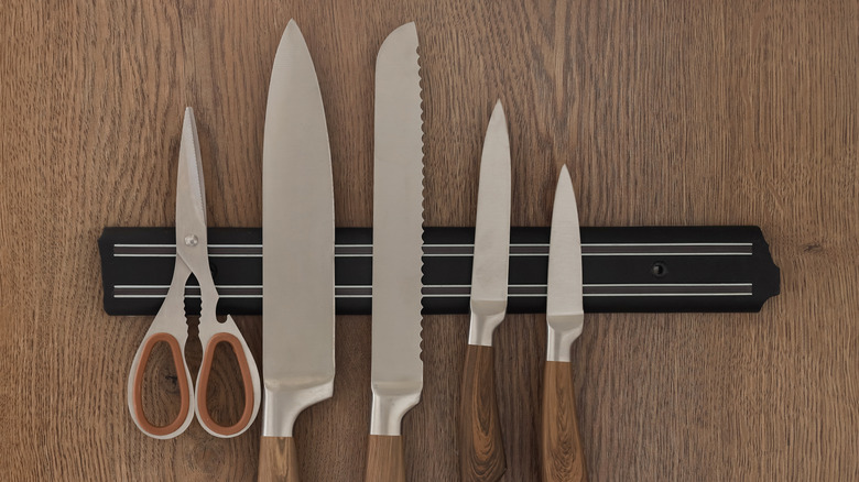 Magnetic knife holder with knives on wood cabinet