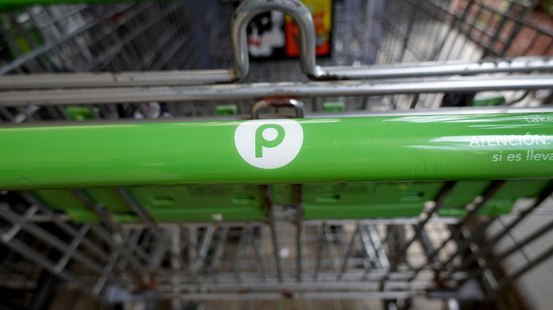 Close up on the green handle of a Publix shopping cart
