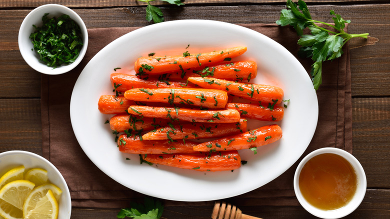 Carrots all about the same size, roasted and honey glazed on a white oval plate