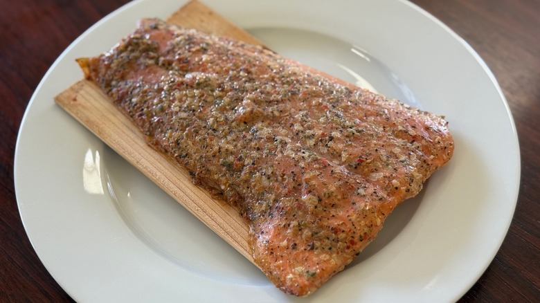 A Monterey Spice salmon fillet on a wood plank on a white plate