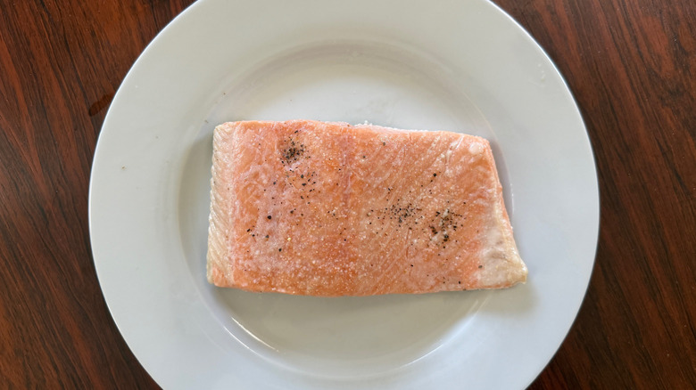 A cooked salmon fillet on a white plate