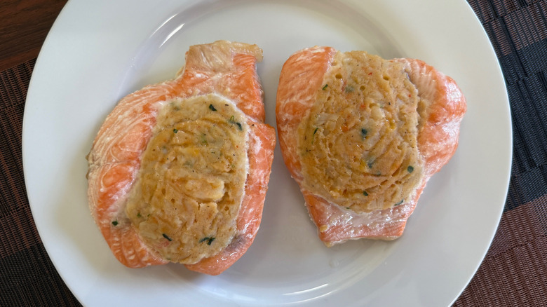 Two pieces of seafood-stuffed salmon on a white plate