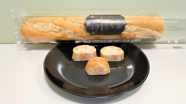 A bag of Specially Selected French Baguette next to a black plate with several bread slices