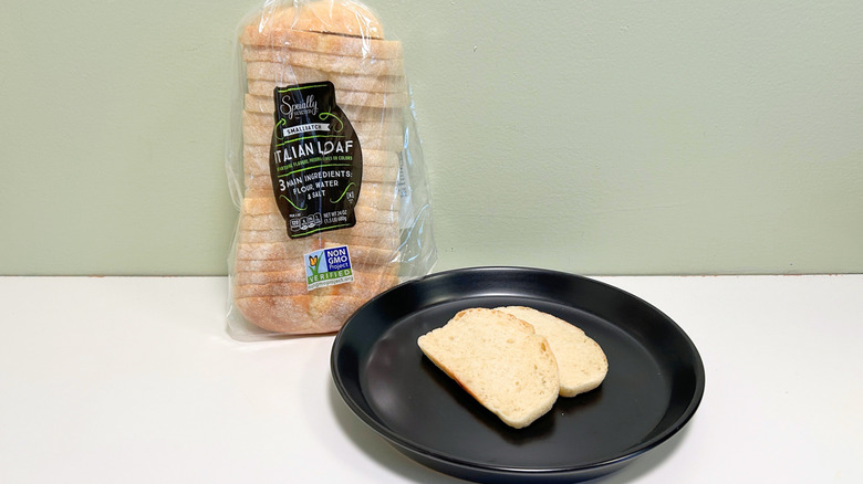 A bag of Specially Selected Small batch Italian Loaf next to a black plate with bread slices