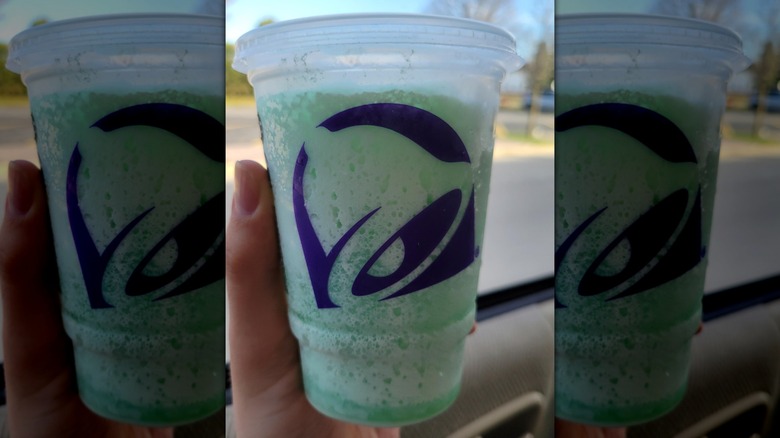 A hand holding a Mountain Dew Baja Blast dirty soda freeze