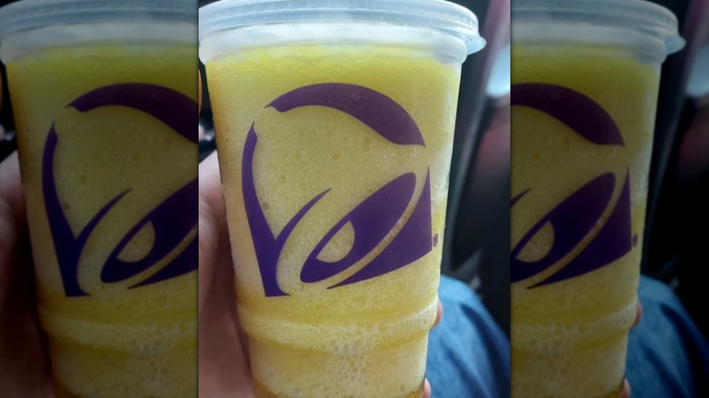 plastic cup of Pineapple Freeze from Taco Bell held in hand