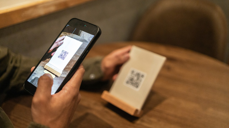 Person scanning QR code menu