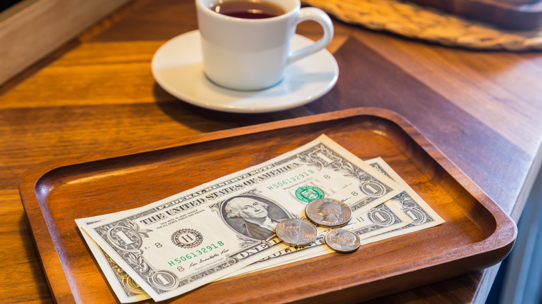 A few dollar bills on the table at a cafe