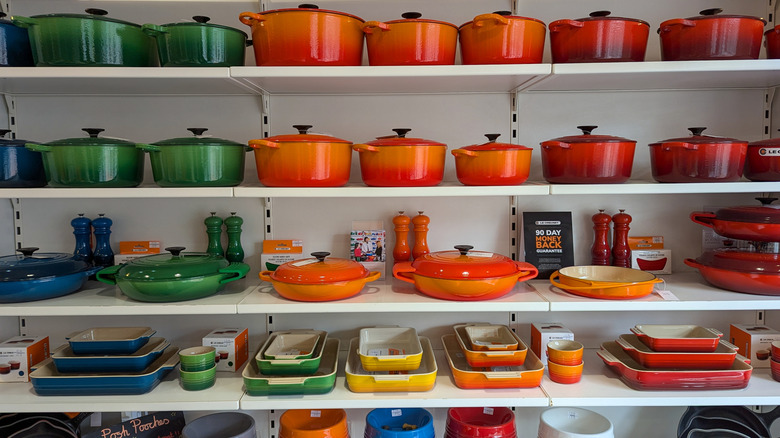 A variety of colorful Le Creuset cookware on display in a store