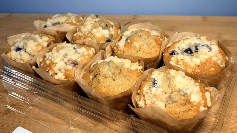 package of eight blueberry muffins in paper wrappers