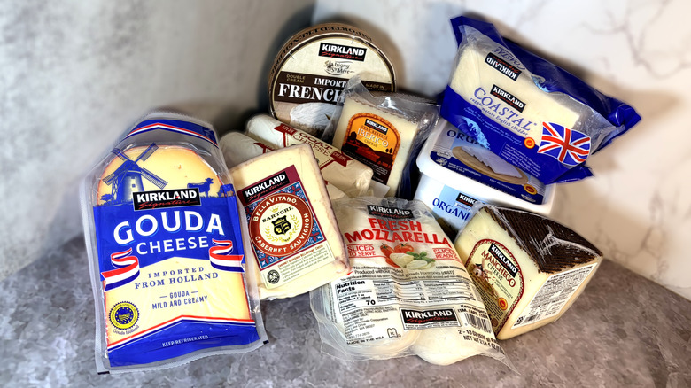 A pile of various packaged Kirkland Signature cheeses on a marble background
