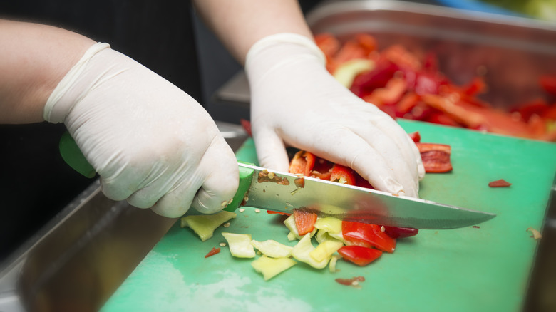person chopping on a green cutting board