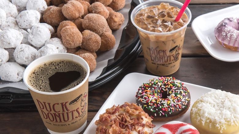 Table with hot coffee, iced coffee, and assorted donuts