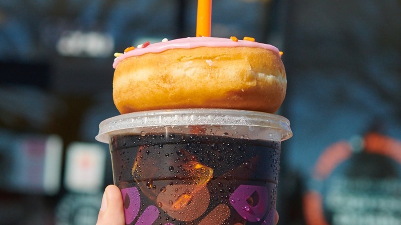 Iced coffee with a donut on top of it