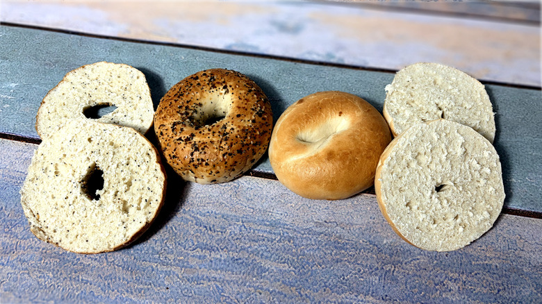 two whole and two sliced bagels on table