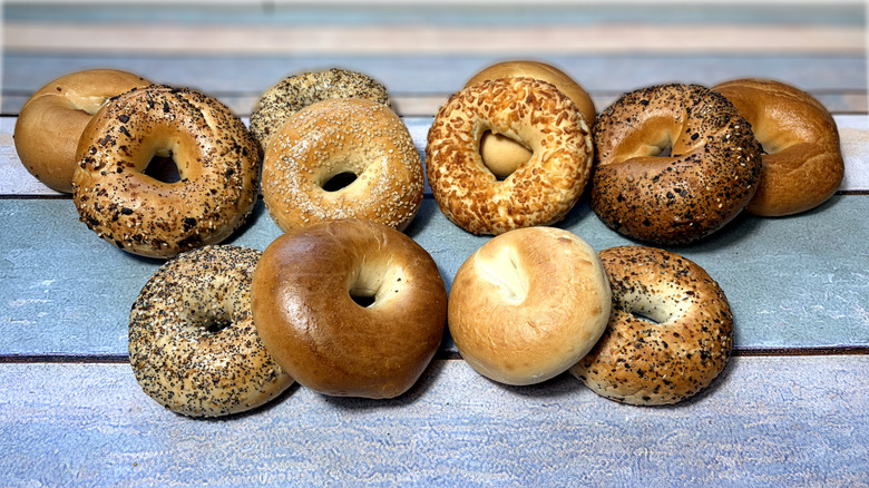 assorted bagels piled in pairs on table