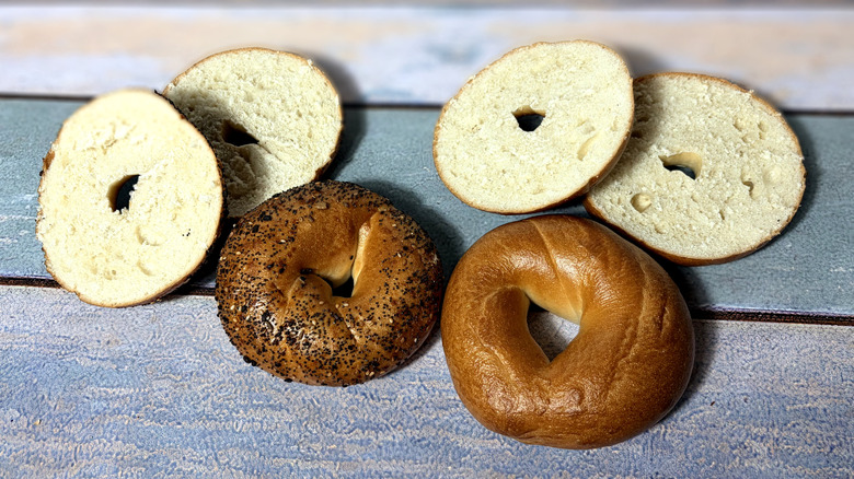two whole and two sliced bagels on table