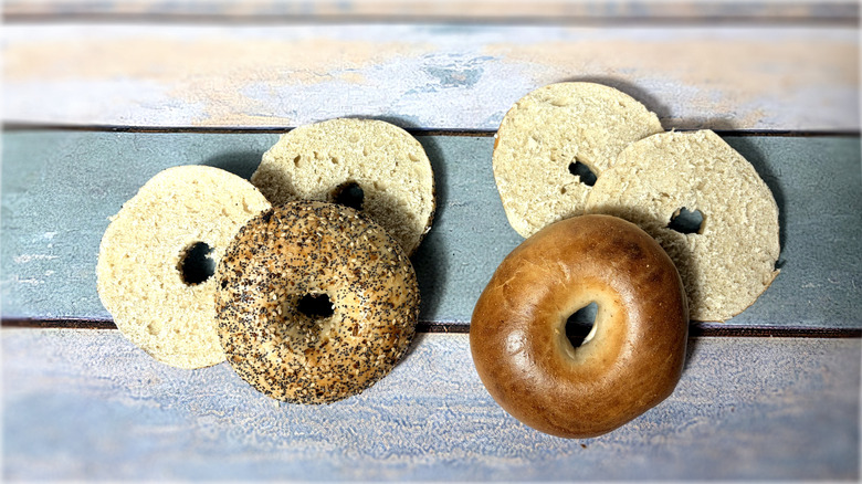 two whole and two sliced bagels on table
