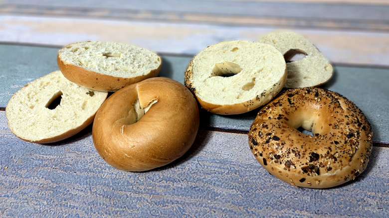 two whole and two sliced bagels on table