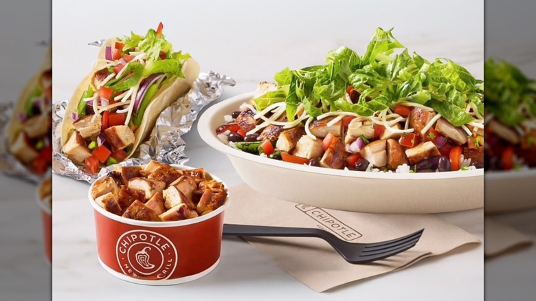 Chipotle's Double High Protein Bowl next to other high-protein menu items on a white counter