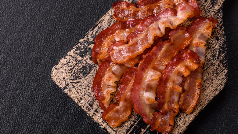 stack of fried bacom on rustic wood board