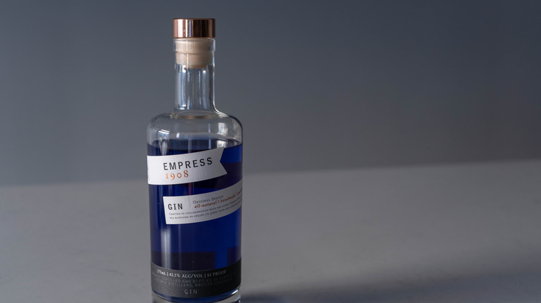 A bottle of Empress 1908 Indigo Gin, displaying its signature indigo color