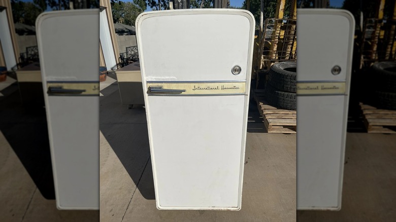 A retro International Harvester refrigerator on cement outdoors