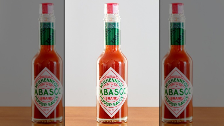 A bottle of red Tabasco Sauce on a gray background
