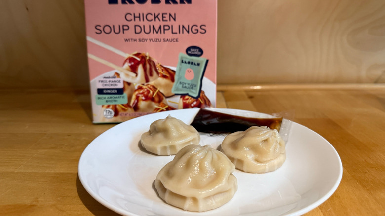Laoban's chicken soup dumplings on a plate with a box in the background