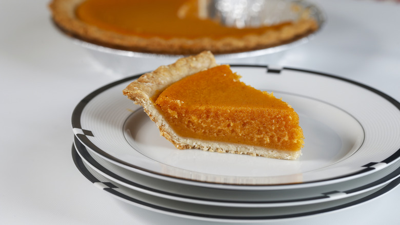 Slice of sweet potato pie on a stack of plates
