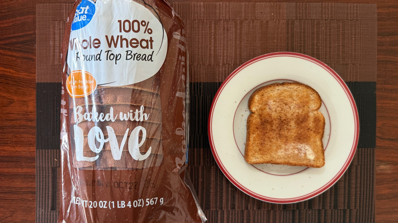 Great Value whole wheat bread in packaging and toasted slice with butter on plate