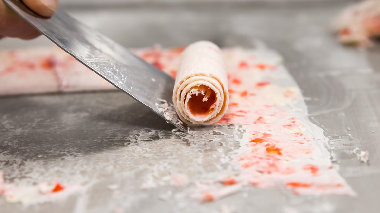 Close up of metal spatula rolling ice cream