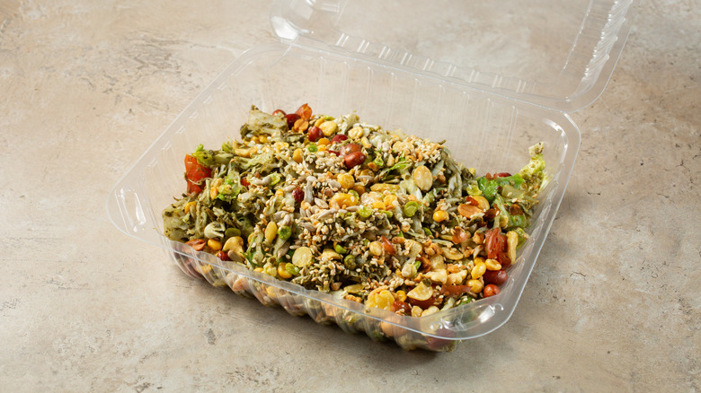 A salad in a plastic clamshell container