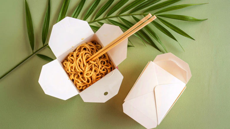 A top-down view of Chinese takeout containers containing noodles