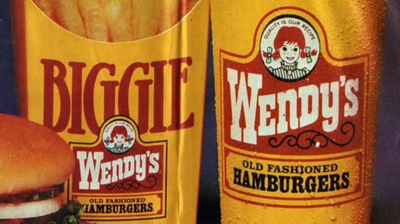 The retro yellow, red, white, and black Wendy's logo on a large fry and a large drink from Wendy's