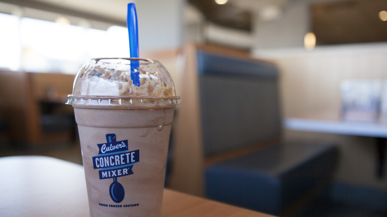 A chocolate Culver's concrete mixer with a blue spoon sticking out of the top