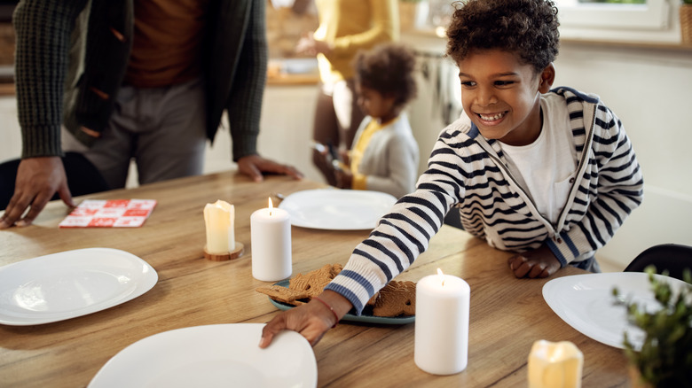 boy sets table for family meal