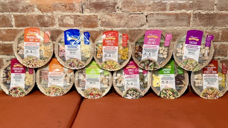 11 Wegmans prepackaged salads against a brick wall