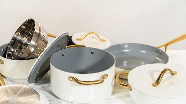 White pots and pans with gold hardware