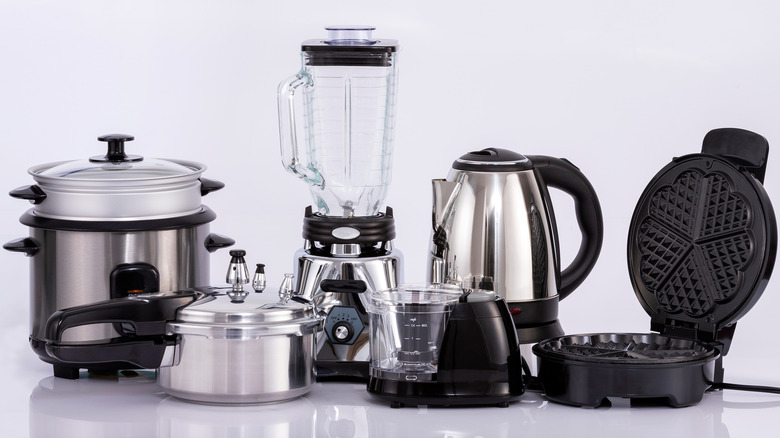 Group of small kitchen appliances on white counter.