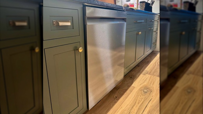 A closed stainless steel dishwasher with no controls on the outside of the door