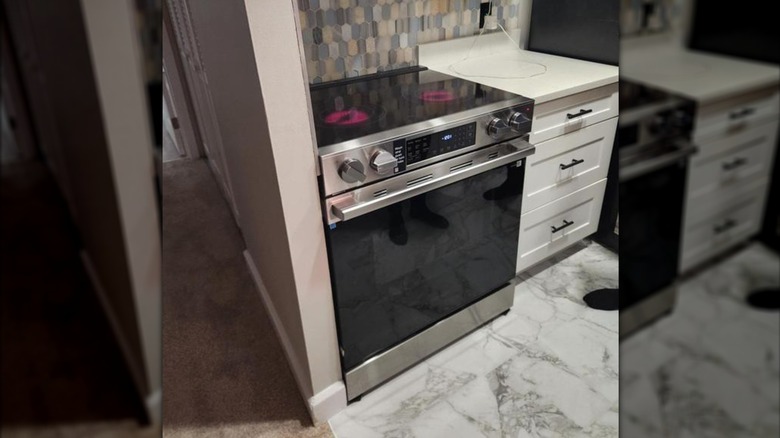 A Samsung range/oven with two glass-top burners glowing red