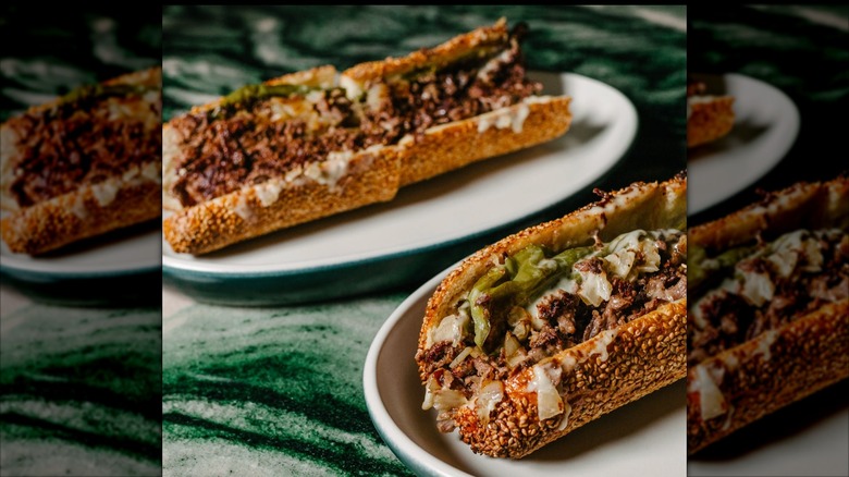 Two Philly-style cheesesteak sandwiches from Matǔ restaurant on white plates